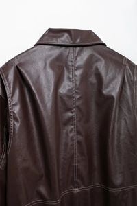 Détail du dos d'une veste en cuir marron avec surpiqûres blanches et col montant