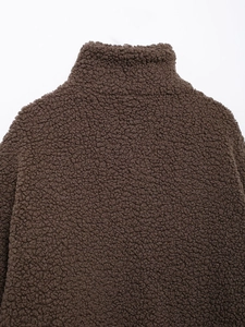 Close-up of deep brown teddy faux fur texture and collar detail on loose fit jacket