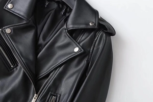 Close-up of black PU leather biker jacket showing collar, silver snaps and metal zippers