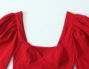 Detailed view of puff sleeves and corset-style bust line on a red French vintage top