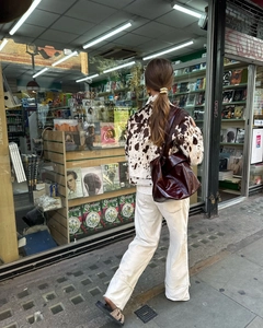 Détail de la veste courte à motif vache et du grand cabas bordeaux en style urbain
