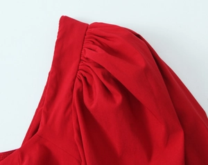 Detailed close-up of pleated puff shoulder on a vintage red long sleeve blouse