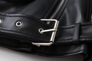 Close-up of black biker leather jacket featuring silver buckle belt and grainy texture