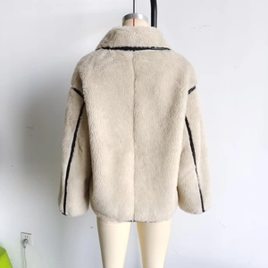 Detail of faux shearling short coat featuring black contrast trim on collar and sleeves