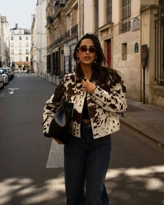 Photo street style d'une veste en jean marron à imprimé vache et jean taille haute