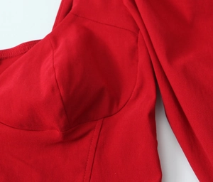 Detail of red French retro top with bustier seam and contrast stitching texture