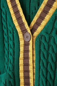 Detailed macro view of green cable knit cardigan with v-neck and contrast stripes