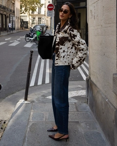 Détail de la veste en jean à imprimé vache avec boutons métalliques et poches de poitrine