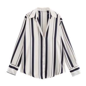 Close-up of vertical black and white striped satin shirt with pearlescent buttons