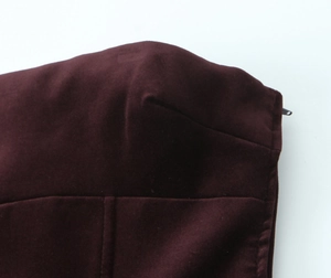 Détail d'une robe en velours bordeaux montrant les coutures et la fermeture éclair