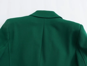 Dettaglio del colletto e della cucitura della spalla di un blazer verde scuro strutturato