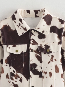 Détails de la veste imprimé vache avec col à revers et poches poitrine à rabat