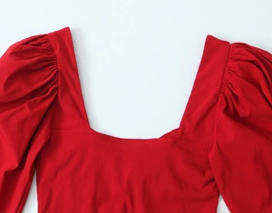 Detail of square neckline and pleated puff sleeves on a vibrant red vintage top