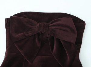 Détail de la robe en velours bordeaux montrant le gros nœud et la fermeture éclair