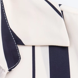 Detailed view of striped satin shirt featuring a crisp white collar and neat stitching