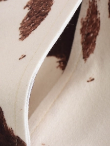 Gros plan détaillé d'une veste motif vache montrant le tissu texturé et les coutures