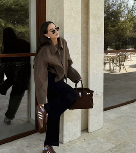 Détail d'une veste courte en laine marron avec fermeture éclair et revers larges de style chic