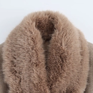 Détail du col en fausse fourrure duveteuse sur un manteau classique en laine de couleur camel