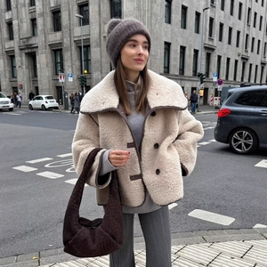 Chic off-white faux fur shearling jacket with brown trim and double-breasted buttons