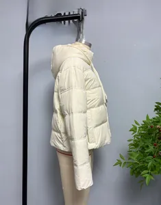 Detail view of women's quilted puffer jacket featuring a windproof hood and side profile