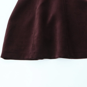 Gros plan du tissu de robe en velours bordeaux avec coutures et détails d'ourlet