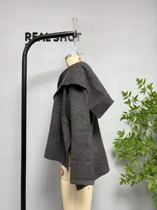 Detail of dark grey knit texture and asymmetric scarf collar on hooded coat