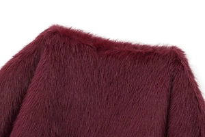 Close-up of fluffy burgundy faux fur texture on a cropped autumn jacket for women