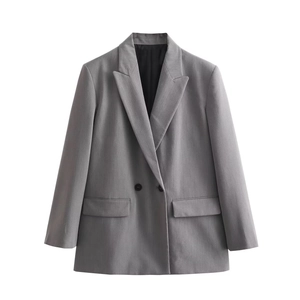 Detail eines grauen Doppelreiher-Blazers mit steigendem Revers und Pattentaschen auf Weiß