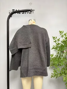Detail view of the back of a dark grey knit cardigan with an asymmetrical scarf collar