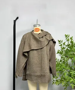 Detail of brown asymmetric knit coat featuring a large shawl collar on a mannequin