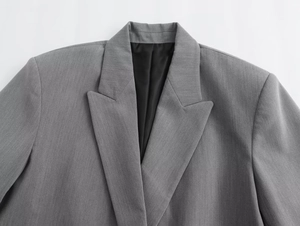 Detailaufnahme von grauem Blazer mit steigendem Revers und schwarzem Innenfutter