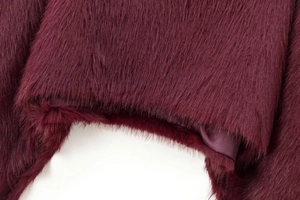 Detailed macro view of burgundy faux fur texture with smooth satin lining fabric