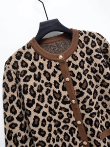 Détail du cardigan léopard avec boutons dorés vintage et bordures côtelées marron clair