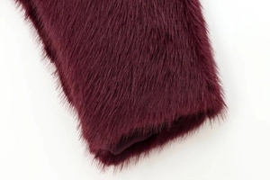 Detail of burgundy faux fur texture and smooth inner lining for luxury jacket