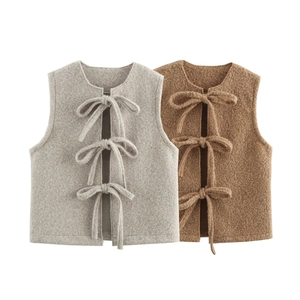 Detail of grey and brown fleece vests with triple bow tie closures and textured fabric