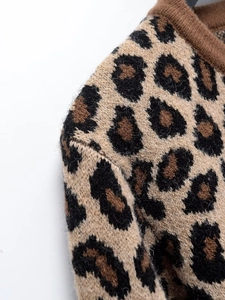 Détail d'un pull en maille léopard montrant la texture de l'épaule et le col côtelé marron