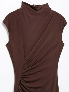 Dettaglio delle eleganti pieghe e del collo alto su questo top smanicato marrone scuro