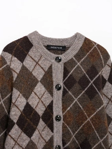 Detailed view of the diamond argyle knit pattern and buttons on the brown cardigan