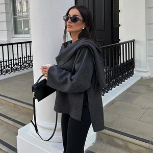 Detail of dark grey knit coat with an asymmetrical scarf collar and high side slits