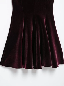 Close-up of wine red velvet pleated skirt hem showing high-quality texture and draping