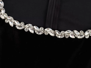 Detail of crystal trim and zipper closure on luxury black velvet square neck dress