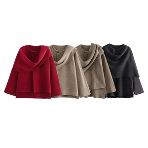Detail view of knit ponchos in red, beige, brown and black with button neck closure
