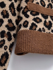 Gros plan détaillé du tricot à motif léopard doux et du poignet côtelé sur le cardigan
