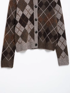 Detail of argyle knit cardigan showing soft brown patterns and four black buttons