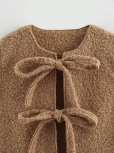 Detail of camel textured fleece vest with double bow tie closures and round neckline