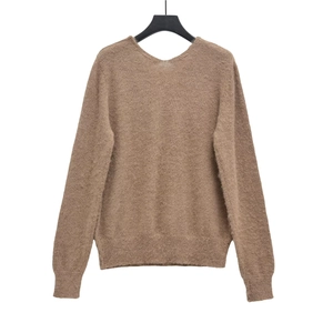 Détail de la texture d'un pull en maille duveteuse avec poignets côtelés et col en V