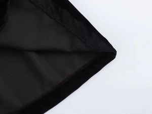 Close-up of black velvet dress showing high-quality stitching and fabric texture