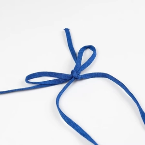 Close-up of the blue knitted halter neck tie detail on the dress with a bow knot