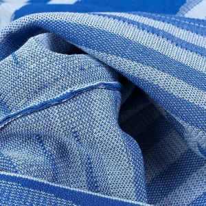 Close-up detail of blue striped knit fabric texture with soft wool fibers on the dress