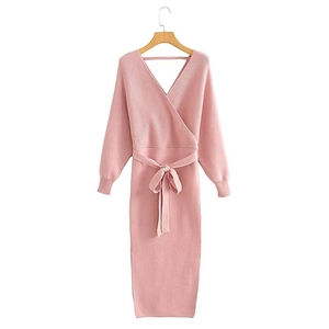 Detailed view of pink knitted dress featuring cross V-neck and stylish waist tie ribbon